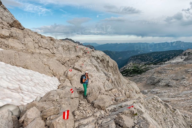Mountaineer on marked route through rocky alpine terrain