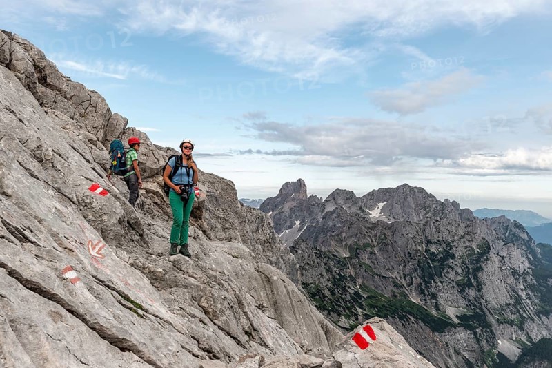 Female mountaineers on marked route through rocky alpine terrain