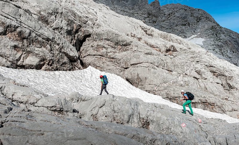 Female mountaineers on marked route through rocky alpine terrain