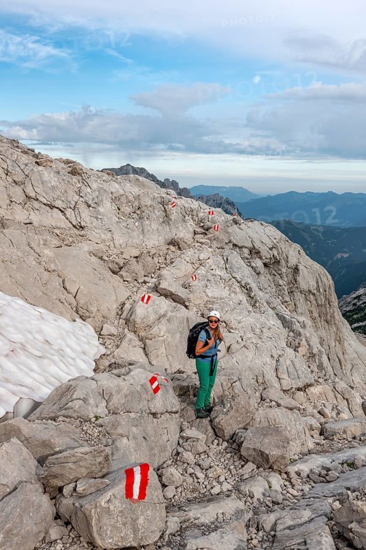 Mountaineer on marked route through rocky alpine terrain