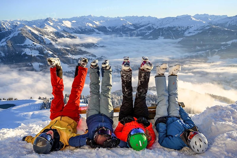 Skiers lie in the snow and stretch their legs in the air