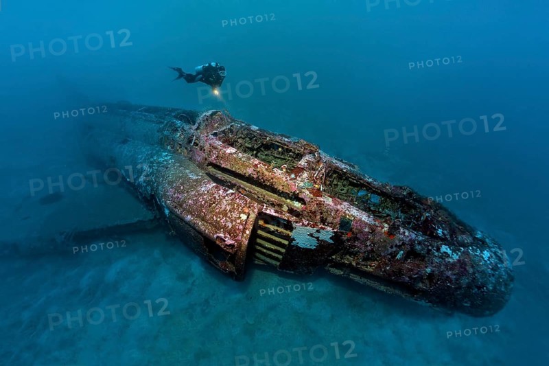 Diver looks at airplane wreck