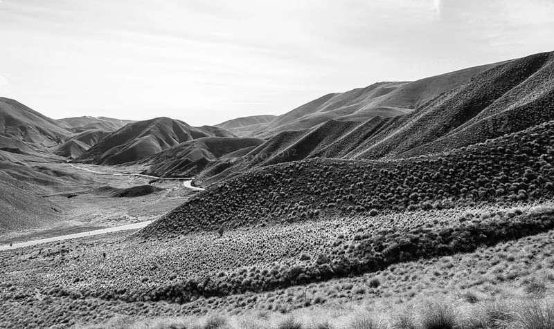 Black and white photo, barren mountain landscape with pass road