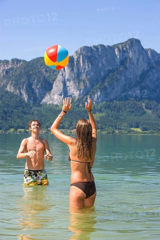 Two teenagers play with water polo in a lake, 18 years