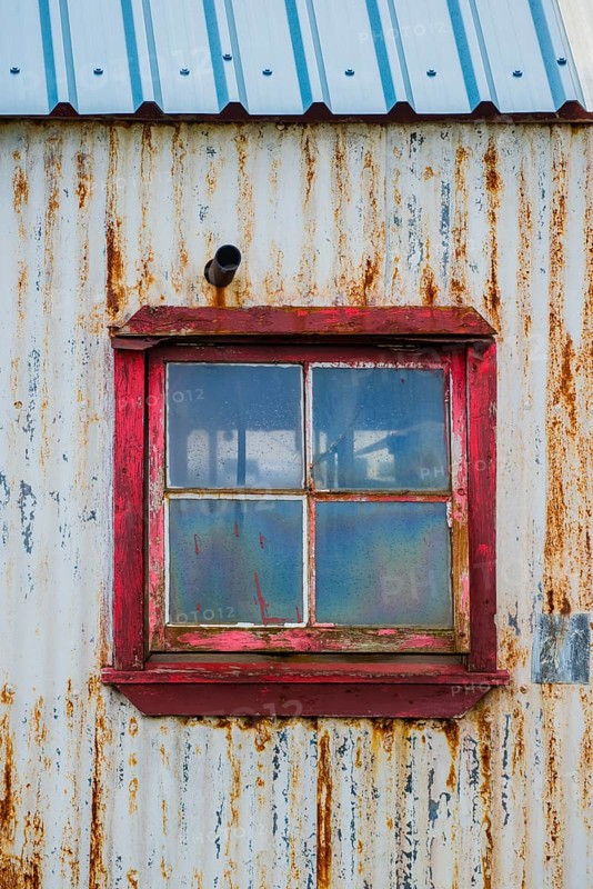 Rusty, weathered corrugated iron facade with window