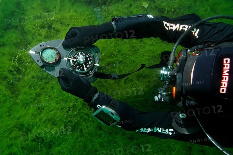 Divers in dry suits orientate themselves with compass in waters with poor visibility, Echinger Weiher