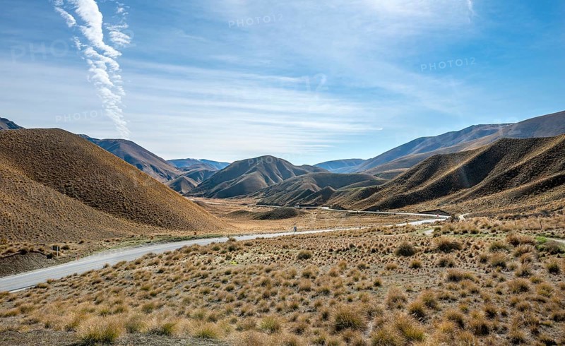 Barren mountain landscape with tufts of grass, pass road