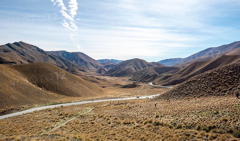 Barren mountain landscape with tufts of grass, pass road