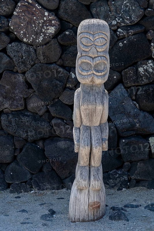 Wooden guardian figure Tiki in front of lava stone wall, Pu'uhonua O Honaunau National Historical Park
