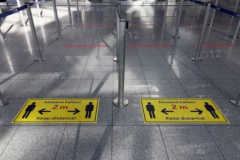 Signs with distance rule in front of the deserted baggage check, flight ban due to corona pandemic