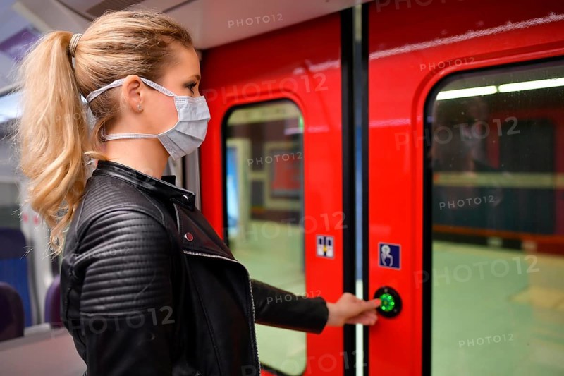 Woman with a face mask, standing in the S-Bahn