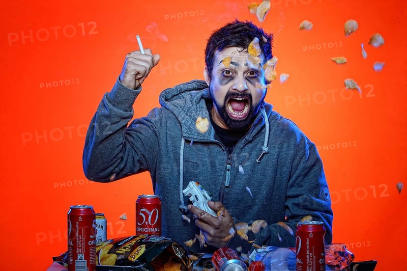 Young man with snacks and gamepad