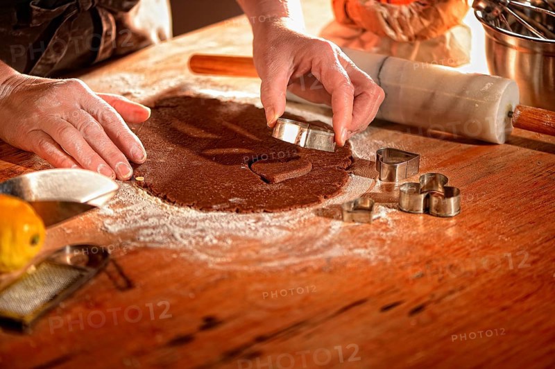 Women's hands pricking cookies from rolled out dough