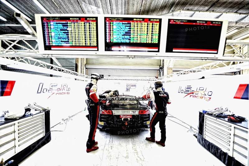 Racing car with pit crew in the pits at the ADAC GT Masters on the Spa-Francorchamps race track