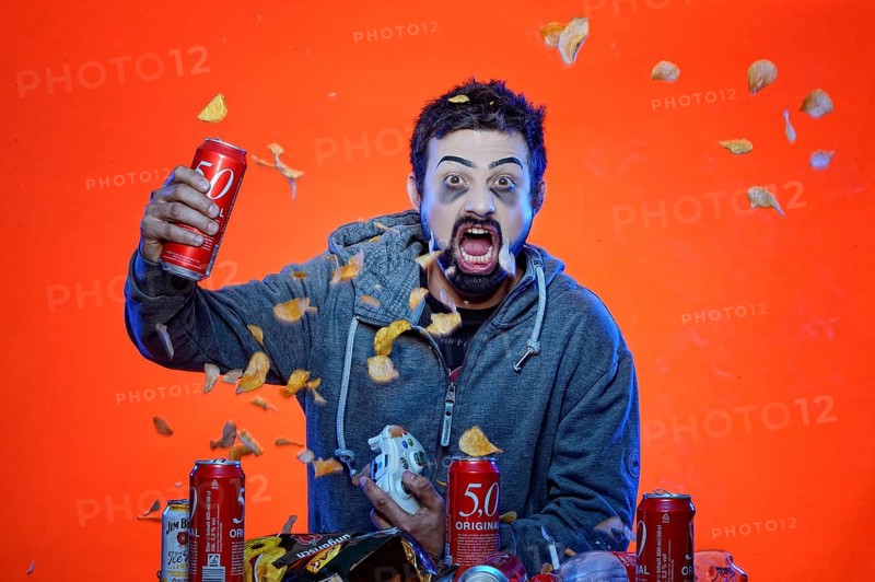 Young man with snacks and gamepad