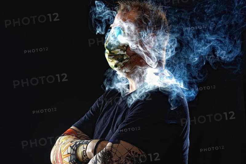 Man with face mask smoking cigarette