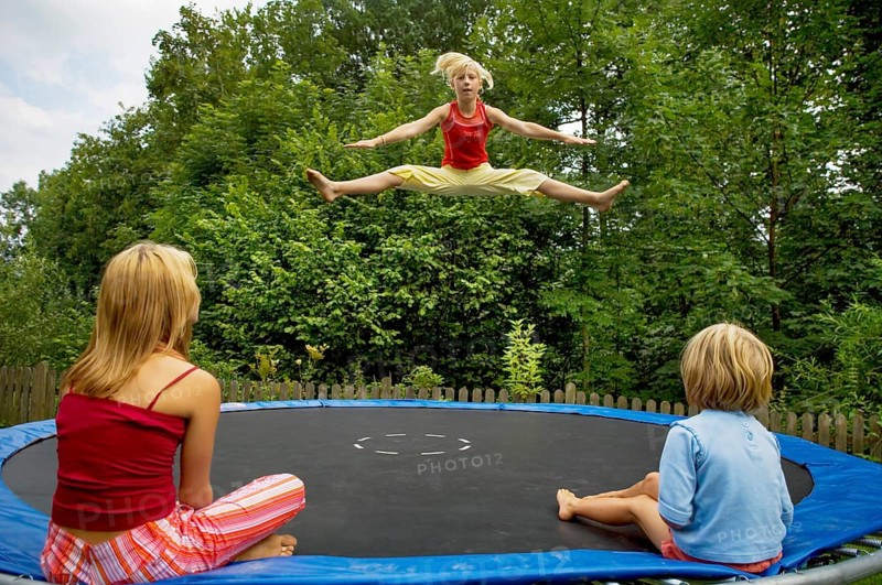 Girls jumping on the trampoline in the garden