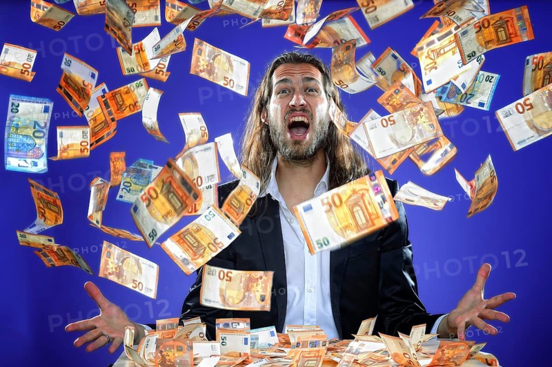 Young man throws banknotes into the air