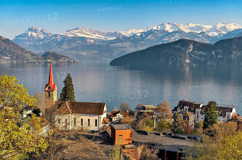 Holiday destination on Lake Lucerne with the parish church of St. Mary behind the snow-covered Alps