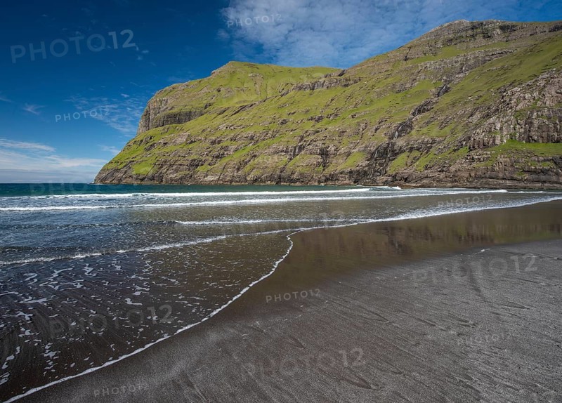 Sandy beach beach in bay surrounded by steep mountains