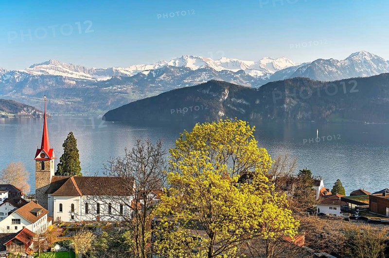 Holiday destination on Lake Lucerne with the parish church of St. Mary behind the snow-covered Alps