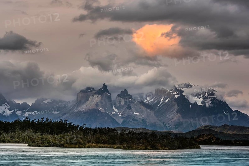 View over the river Rio Serrano to the mountain range Cuernos del Paine with cloudy sky