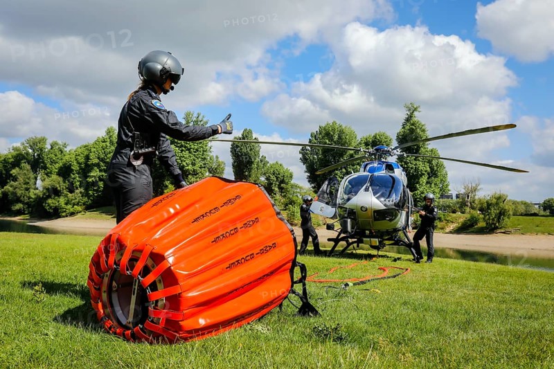 Police helicopter Airbus H 145 during exercise with fire water tank BAMBI BUCKET