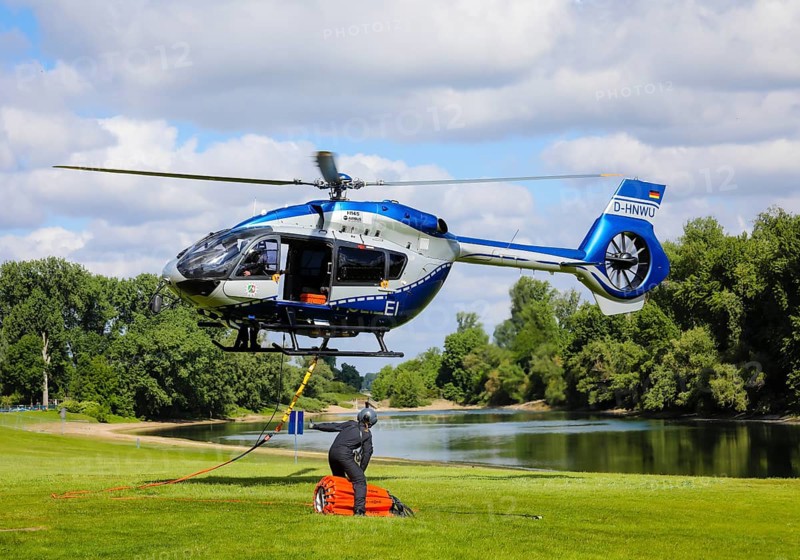 Police helicopter Airbus H 145 during exercise with fire water tank BAMBI BUCKET