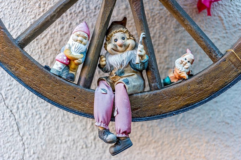 Garden gnomes in wooden wagon wheel
