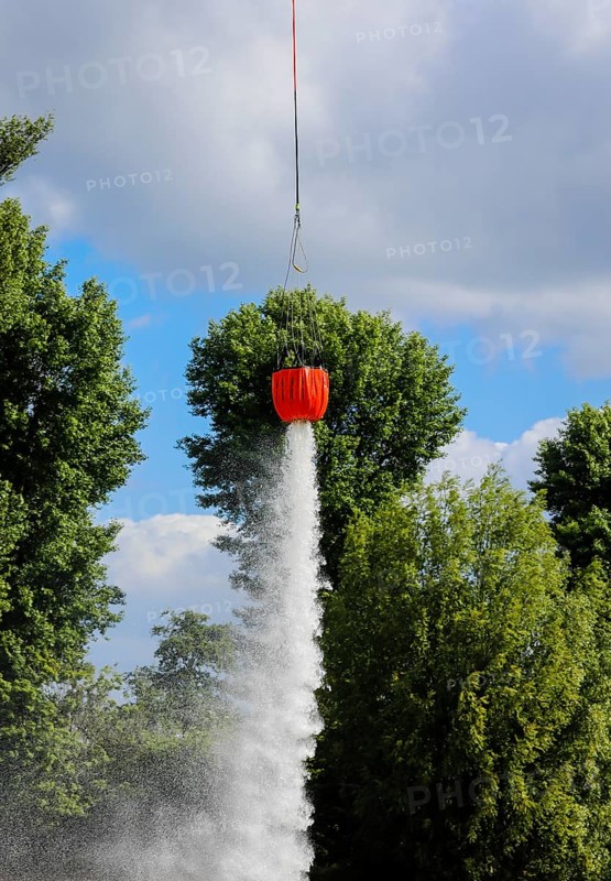 Police helicopter during exercise with fire water tank BAMBI BUCKET