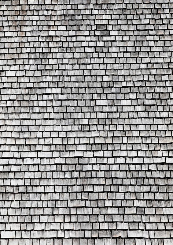 Facade of a wooden house with weathered wooden shingles