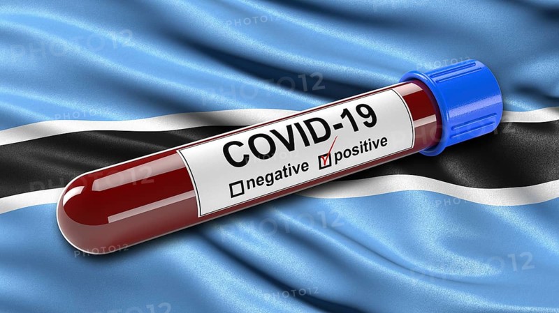 Flag of Botswana waving in the wind with a positive Covid-19 blood tube