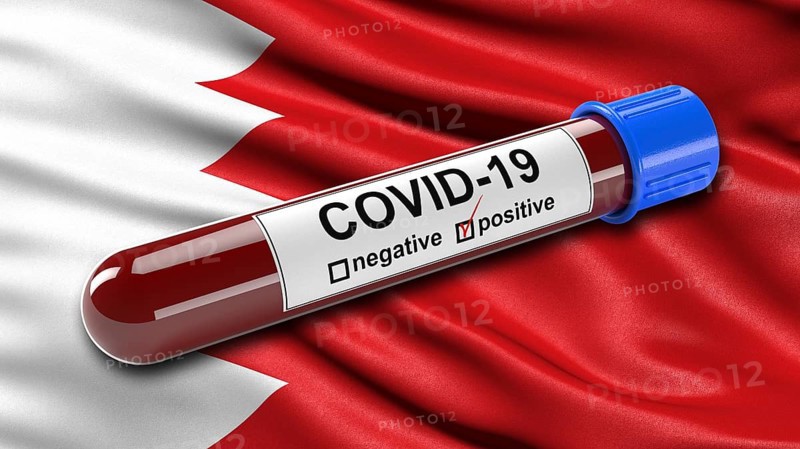 Flag of Bahrain waving in the wind with a positive Covid-19 blood tube