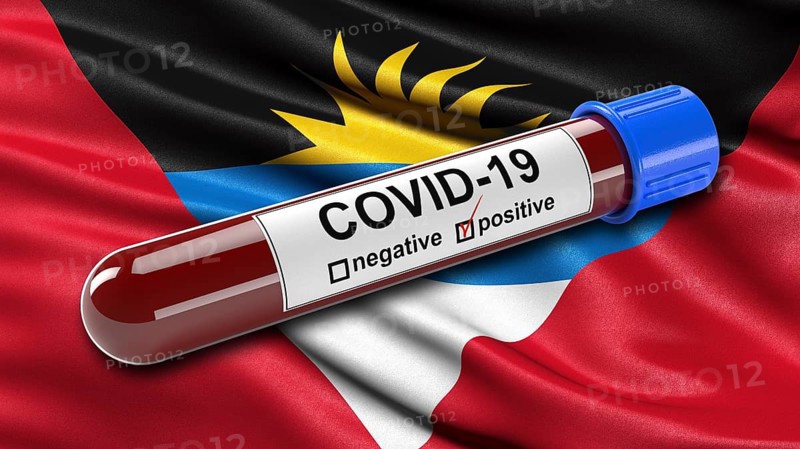 Flag of French Polynesia waving in the wind with a positive Covid-19 blood tube