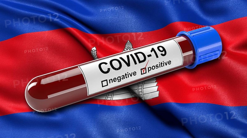 Flag of Cambodia waving in the wind with a positive Covid-19 blood tube