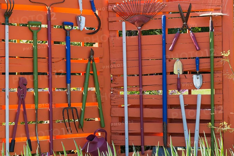 Various garden tools hanging on wooden wall Shovels