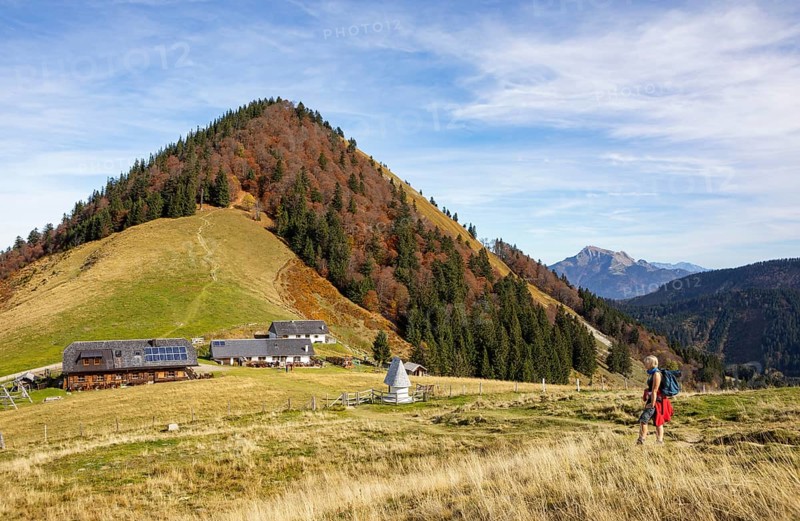 Hiker in front of the Doellererhuette and Lanznhuette on the Oberwiesalm