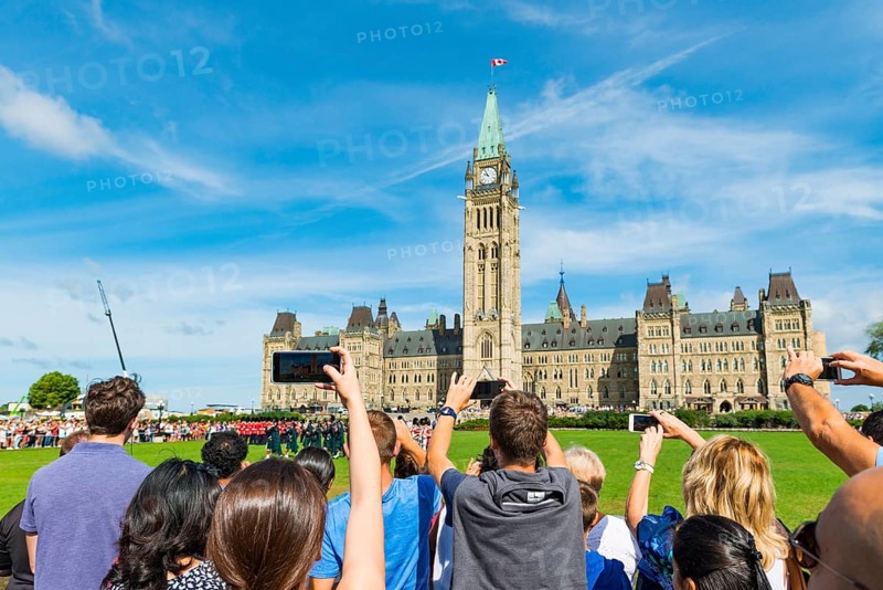 Visitors photograph the changing of the guard in front of the Canadian Parliament Building Centre Block