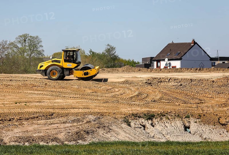 A road roller compacts the dam above the elevated sewer in the construction site