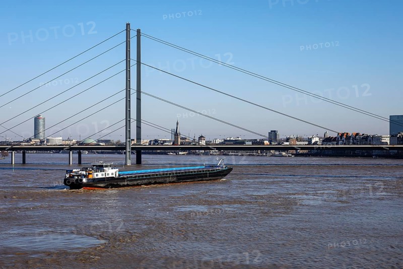 Freighters navigating at high water on the Rhine under the Rheinkniebruecke