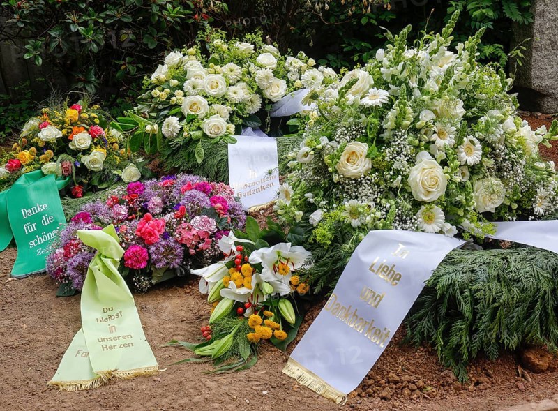 Mourning wreaths with ribbons on a fresh grave