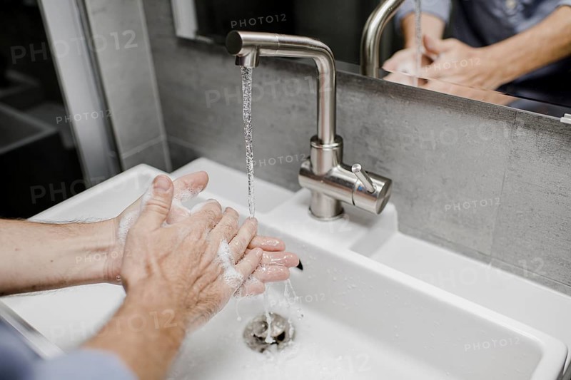 Man washing his hands at the sink