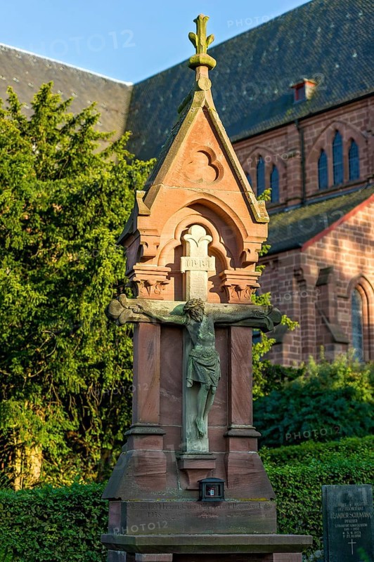 Crucifix in front of the neo-gothic collegiate church of St. John the Baptist