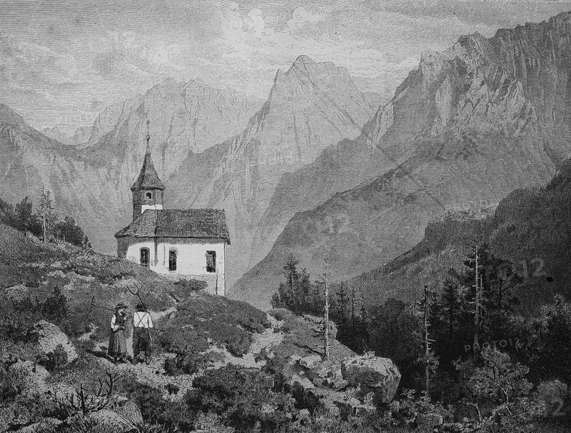 A farmers couple near a chapel at the Kaiser Mountains