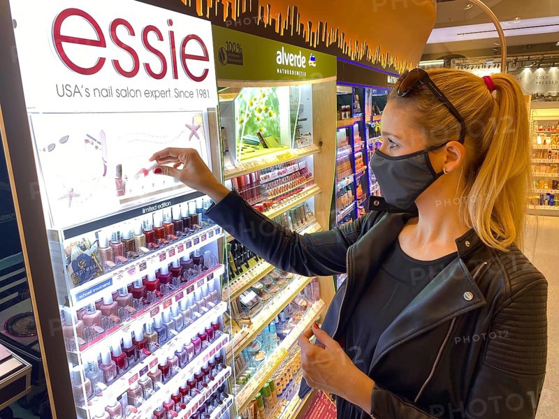 Woman wearing a face mask while shopping in the cosmetics department