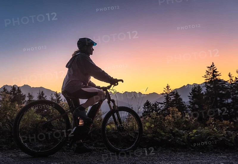 Silhouette of a female mountain biker in dusk