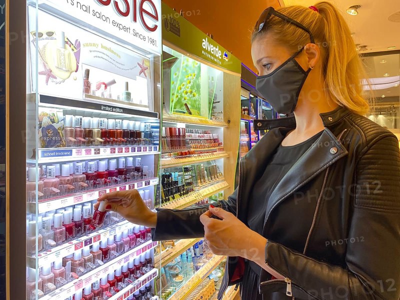 Woman wearing a face mask while shopping in the cosmetics department