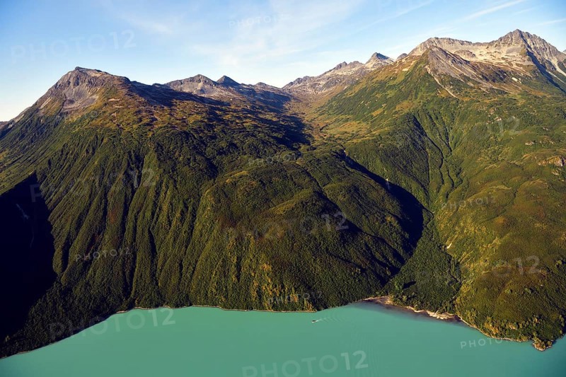 Steep forested mountainsides and an emerald green lake