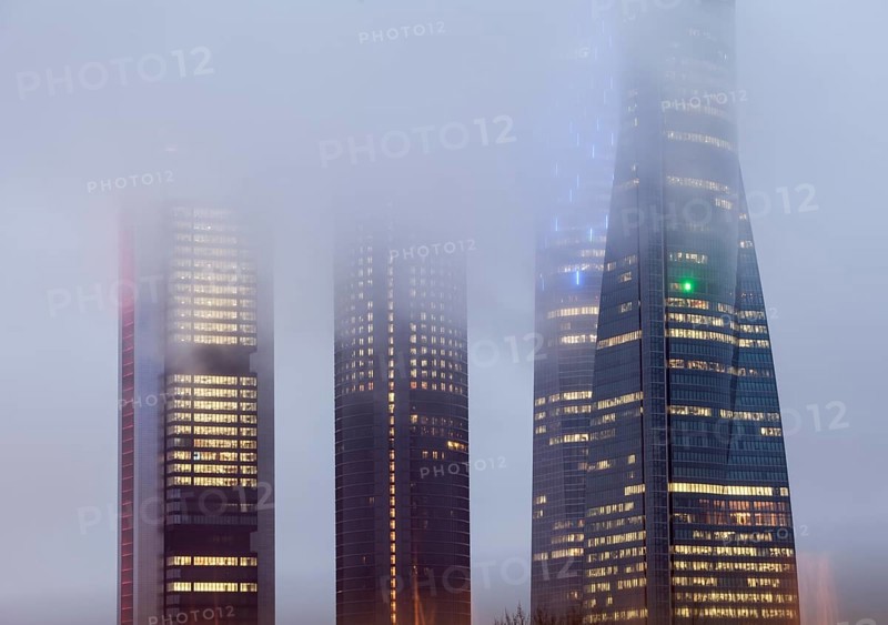 Cuatro Torres Business Area Office building illuminated in evening fog