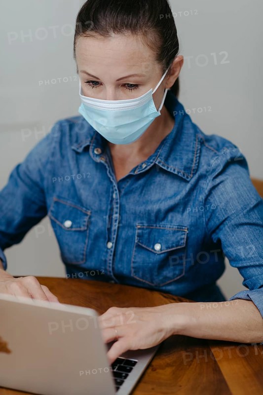 Woman with mouth guard on laptop